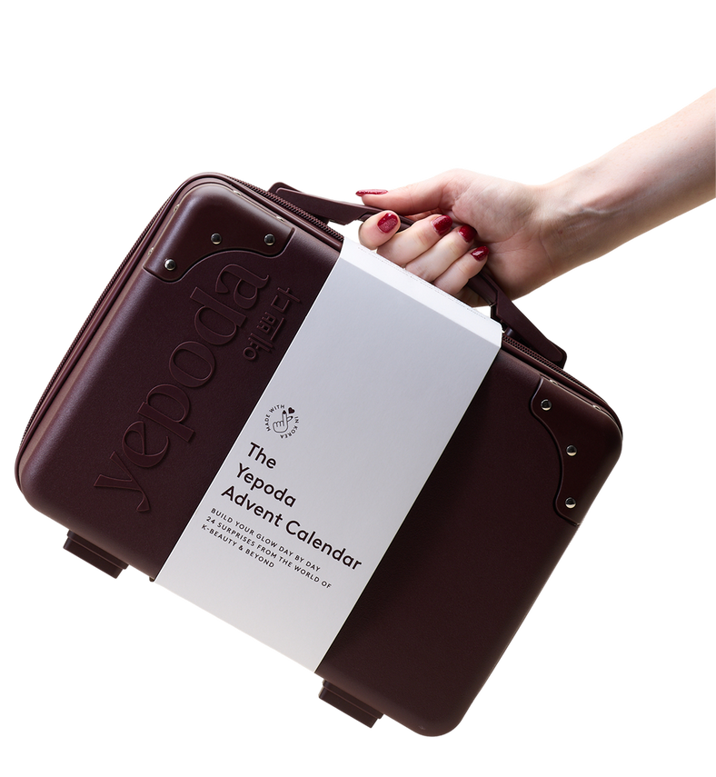 Une main tient une valise bordeaux The Yepoda Advent Calendar